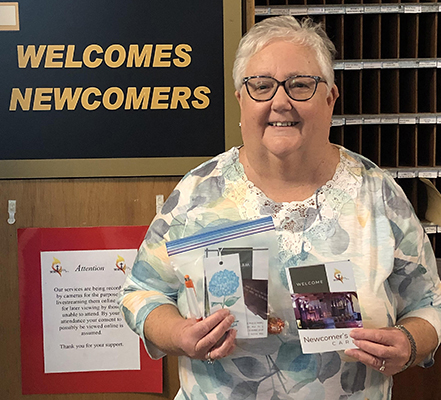 Greeter holding up literature and brochures